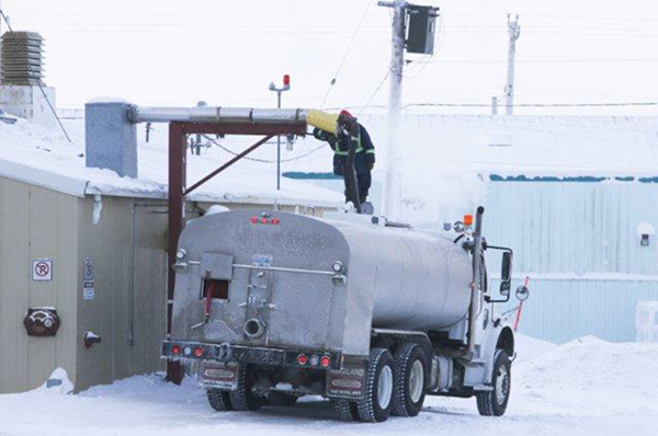 Opérateur en train de remplir un camion de distribution d'eau potable